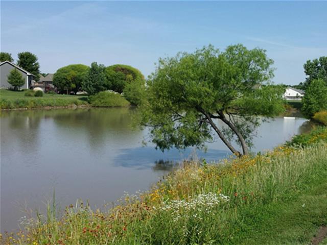 A scenic pond bordered by grass and trees